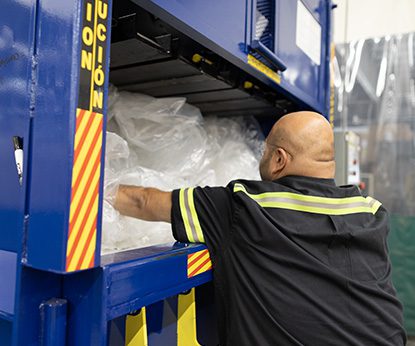 PADNOS employee baling recycled plastic for better processing.